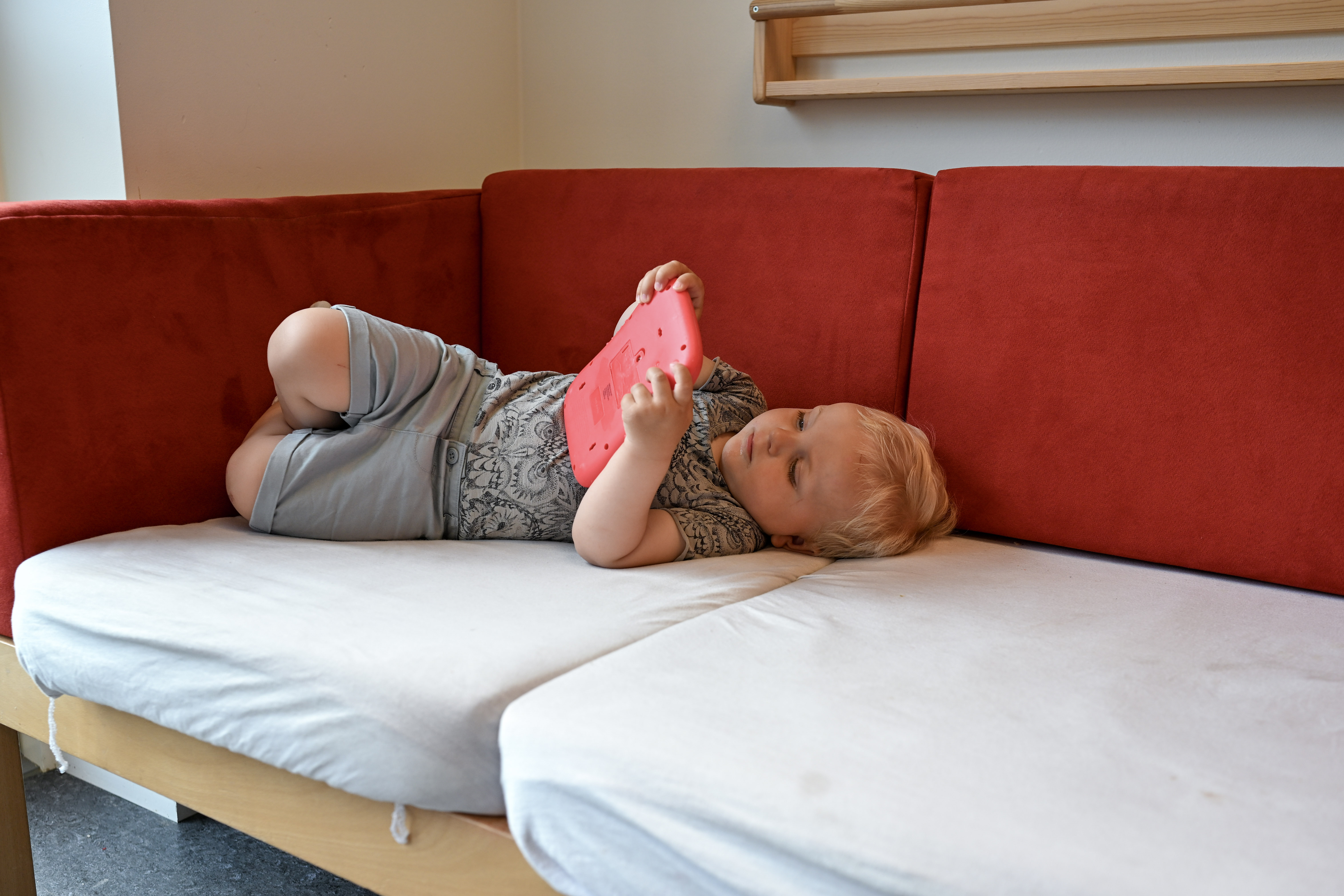 Barn ligger på sofa